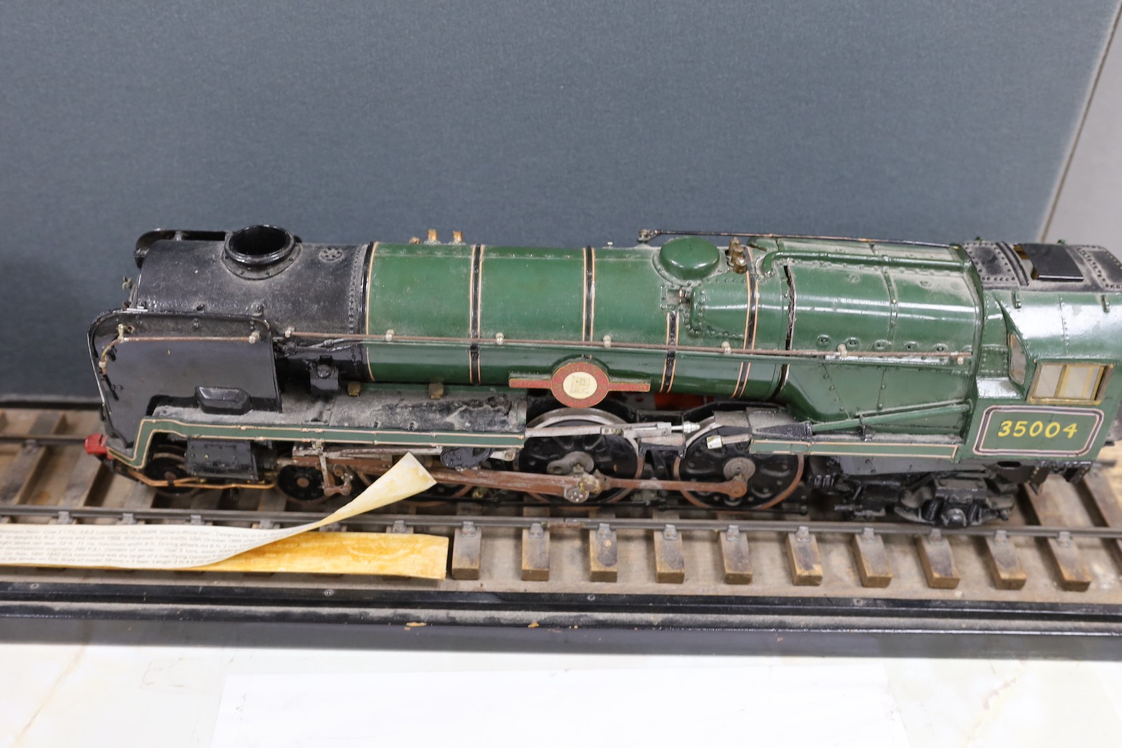 A scratch built scale model ‘S.R./B.R. Modified ‘Merchant Navy’ Class 3 CYL. 4.6.2 Locomotive No.35004 ‘Cunard-White Star’’ and carriage on track. Track length 94.5cm